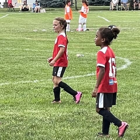 two girls in red soccer jersey